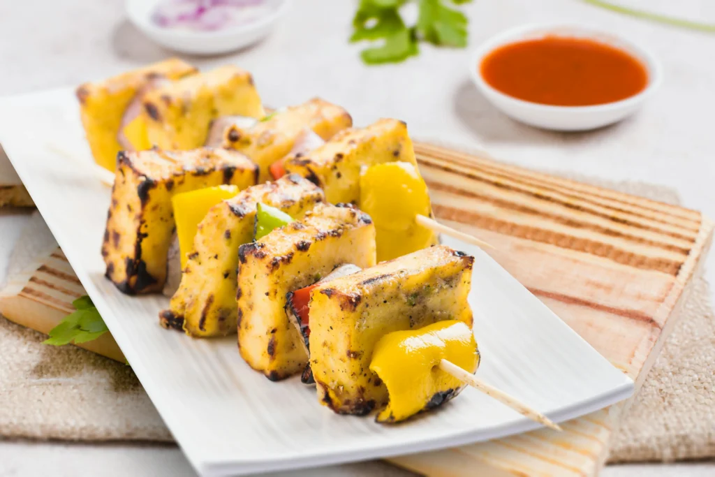 Golden fried paneer cubes with colorful bell peppers in spicy sauce - Chilli Paneer