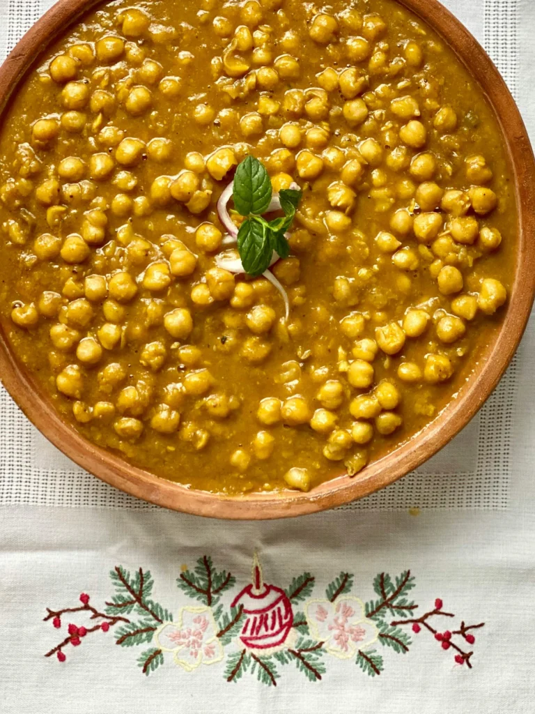 A family gathered around the dining table, enjoying a wholesome meal of Chana Masala together, highlighting the joy of sharing delicious food with loved ones.