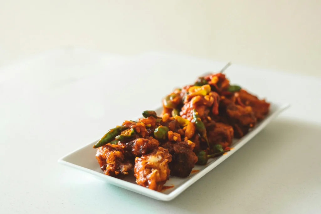 A plate of freshly prepared Mushroom Manchurian, garnished with chopped spring onions