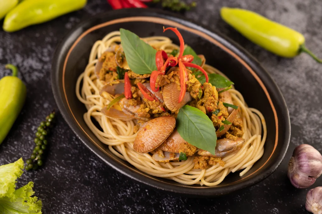 Fresh lo mein noodles being tossed with tender chicken, snap peas, and green onions in a savory sauce