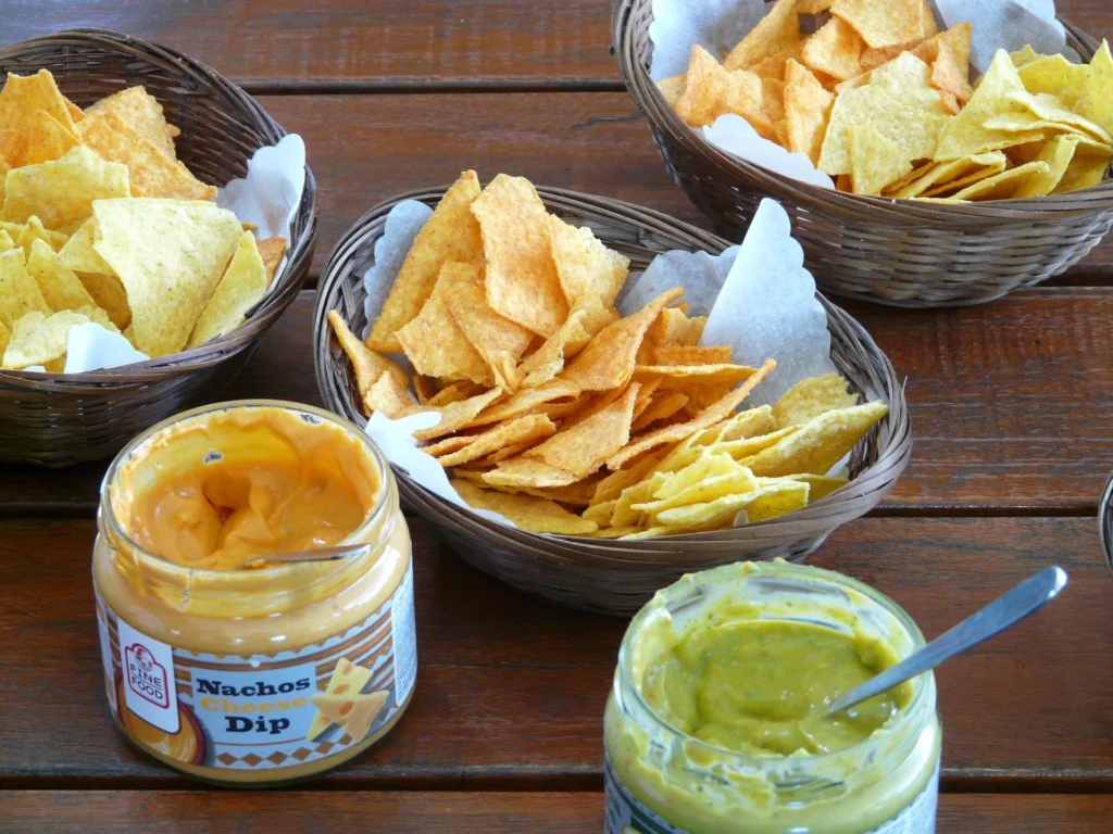 Delicious homemade vegetarian nachos topped with avocado, sour cream, salsa, and cilantro