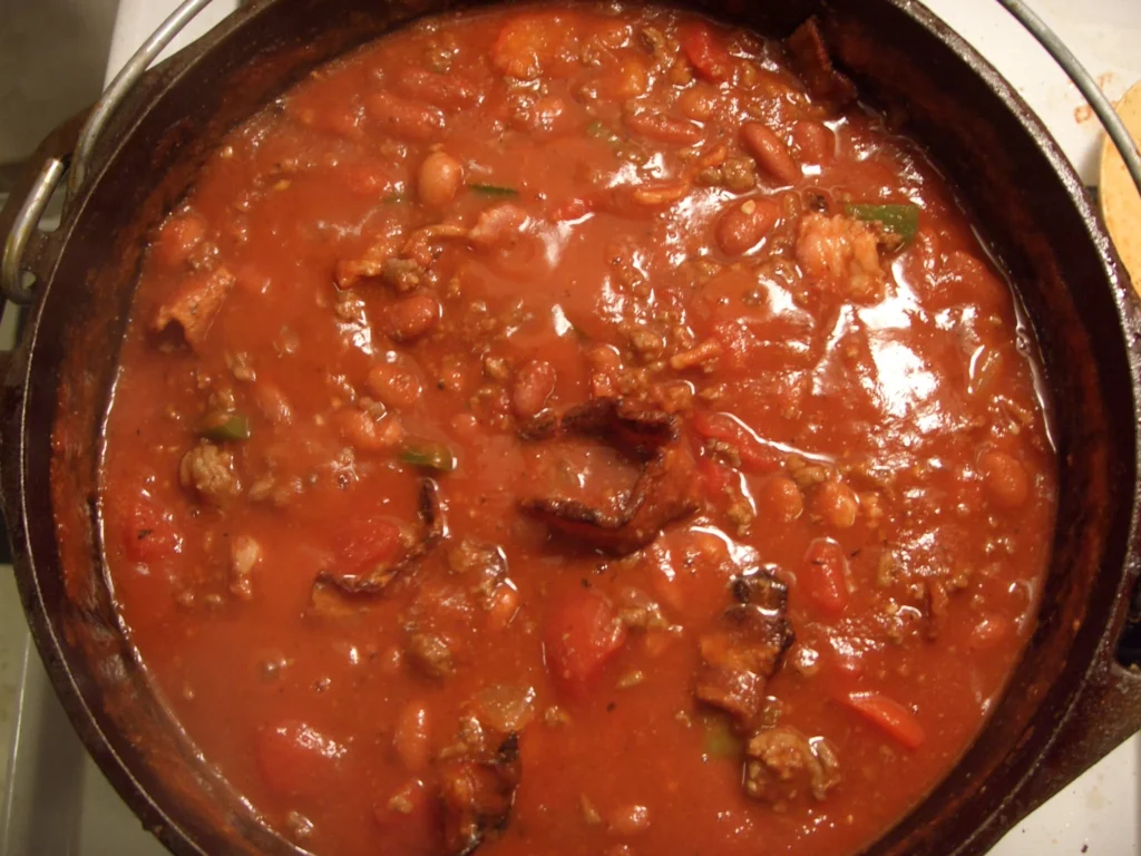 A close-up of a simmering pot of Texas chili, highlighting the vibrant colors