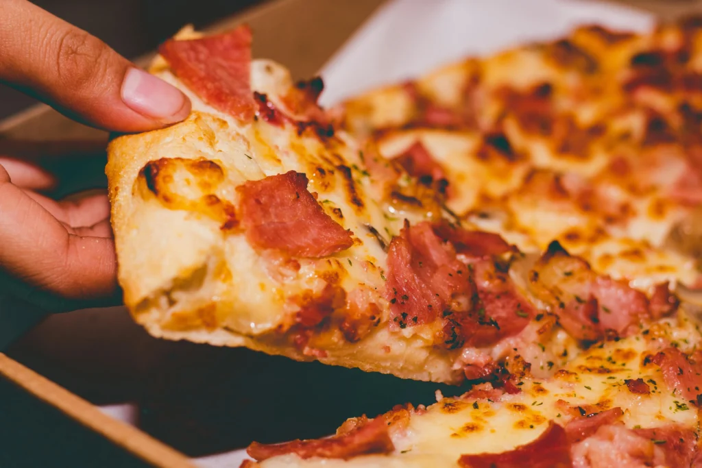 Close-Up Photo of Person Holding hawaiian pizza