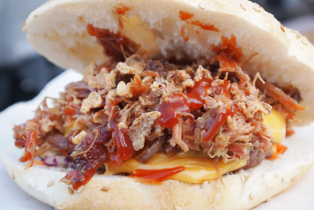 Close-up of a pulled pork sandwich with coleslaw on a toasted bun