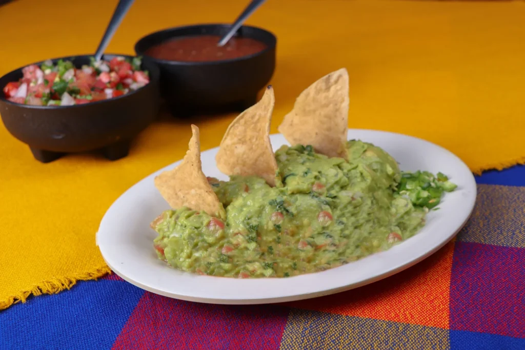 Freshly made guacamole salsa in a bowl with tortilla chips