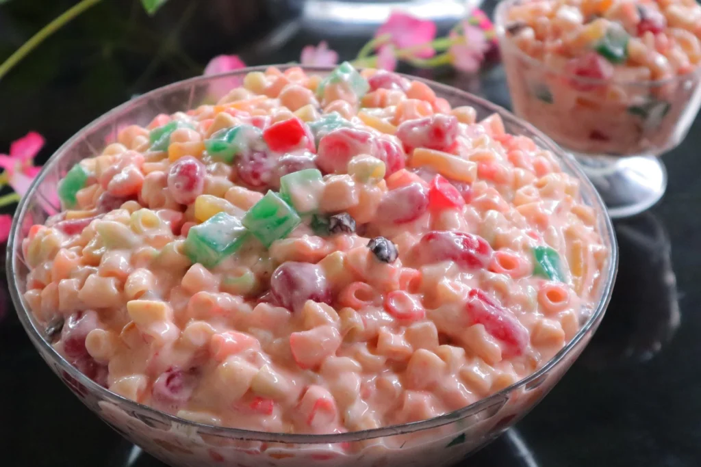 A bowl of Hawaiian macaroni salad garnished with chopped green onions, ready to be served