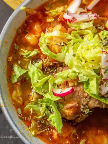 A close-up of a spoonful of pozole blanco showing the tender meat and hominy