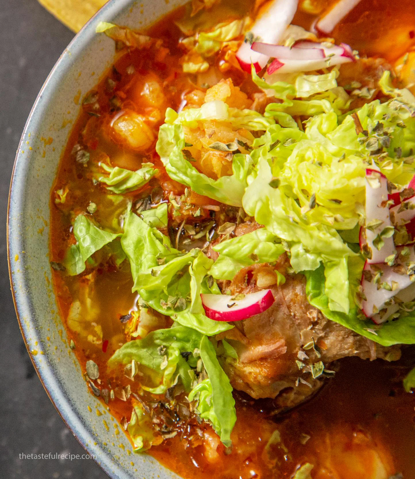 A close-up of a spoonful of pozole blanco showing the tender meat and hominy