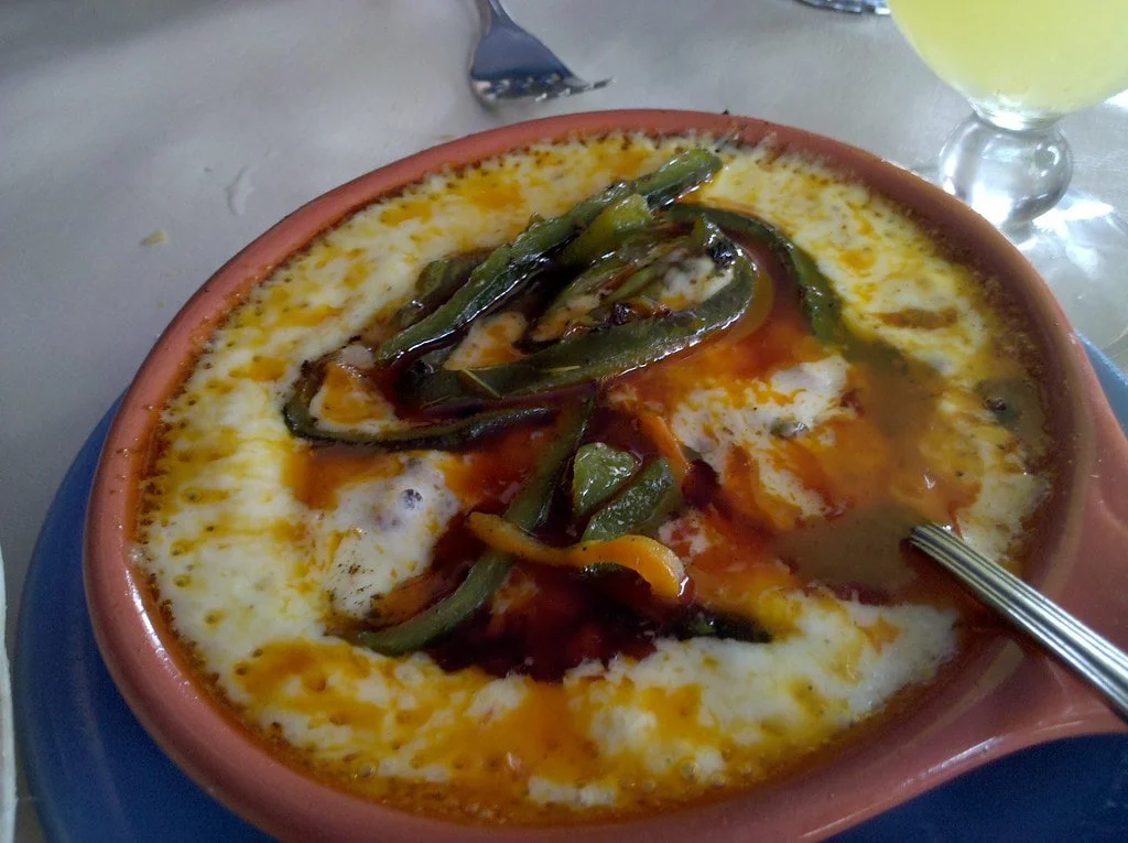 Freshly baked Queso Fundido bubbling in the oven, ready to be served as a delicious appetizer