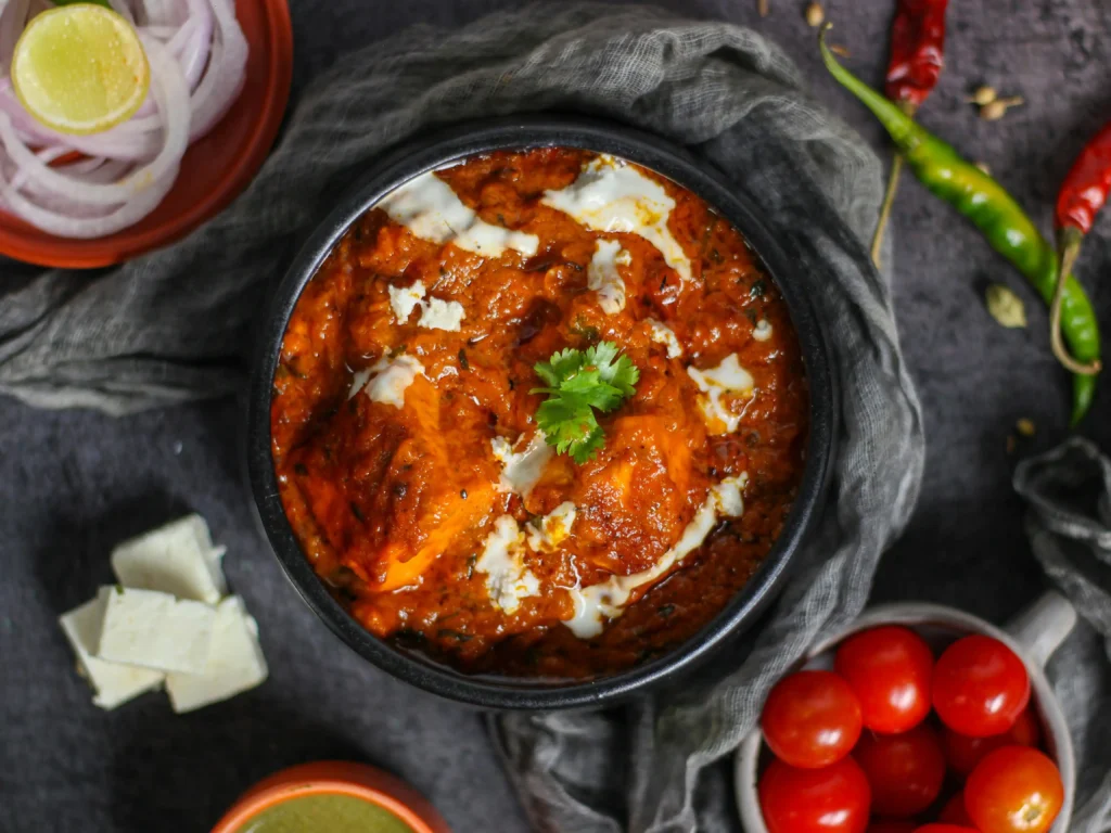 Cooked paneer butter masala in Black Ceramic Bowl