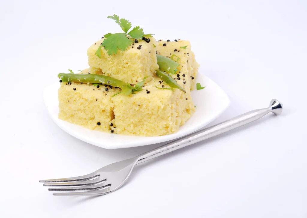 Dhokla garnished with freshly grated coconut and chopped coriander leaves