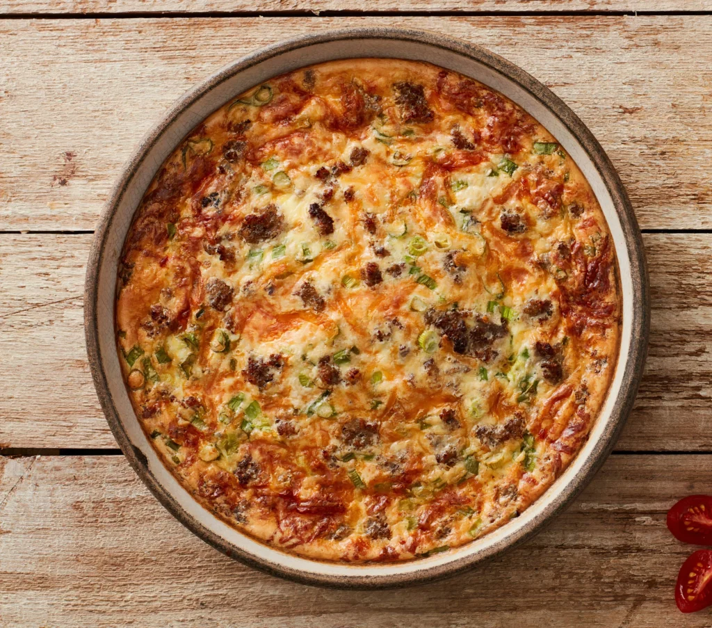 Close-up of bubbling Queso Fundido in a cast-iron skillet, garnished with chopped cilantro