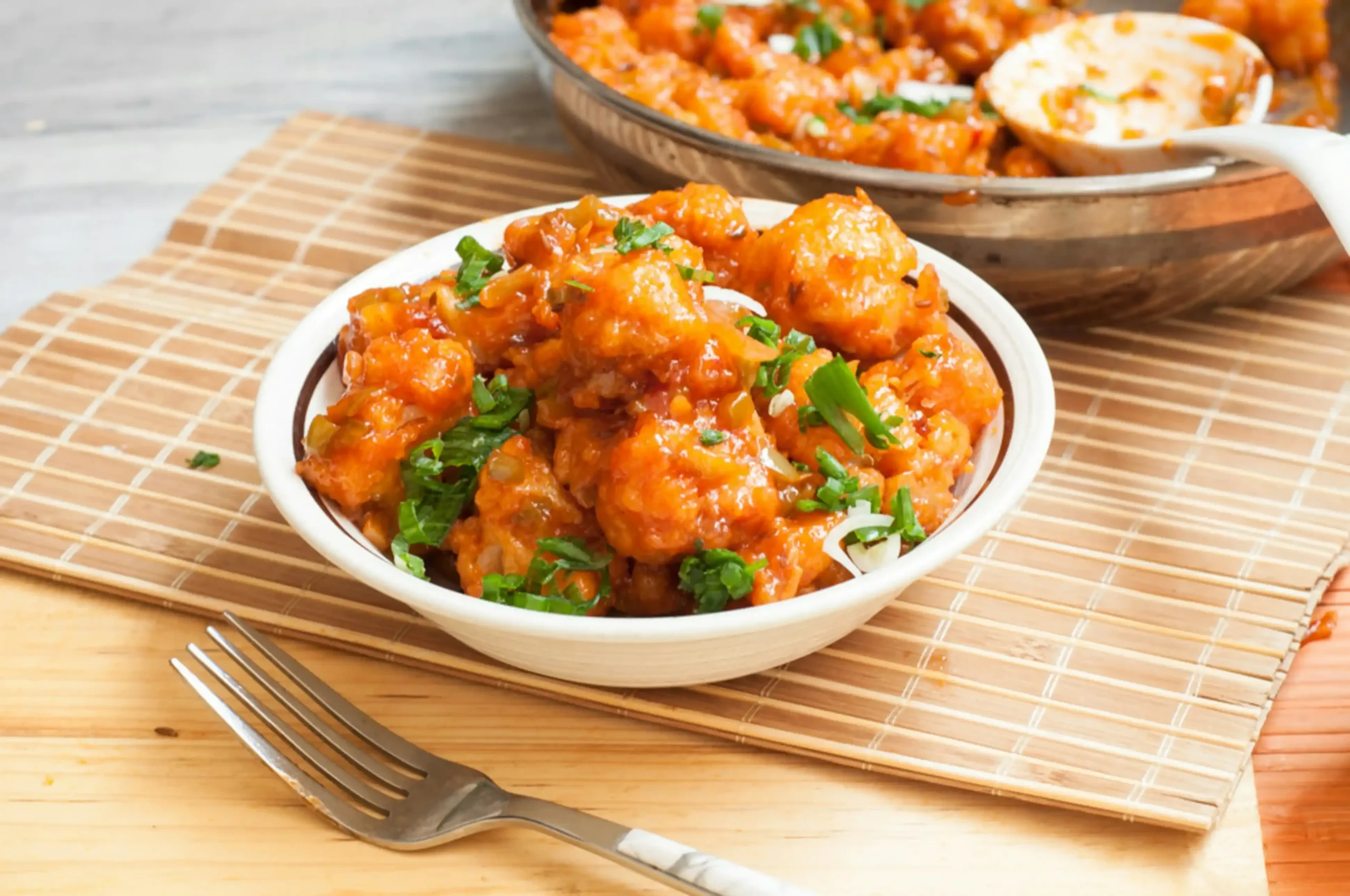 Aloo Gobi simmering in a pan, covered with a lid, allowing the flavors to meld