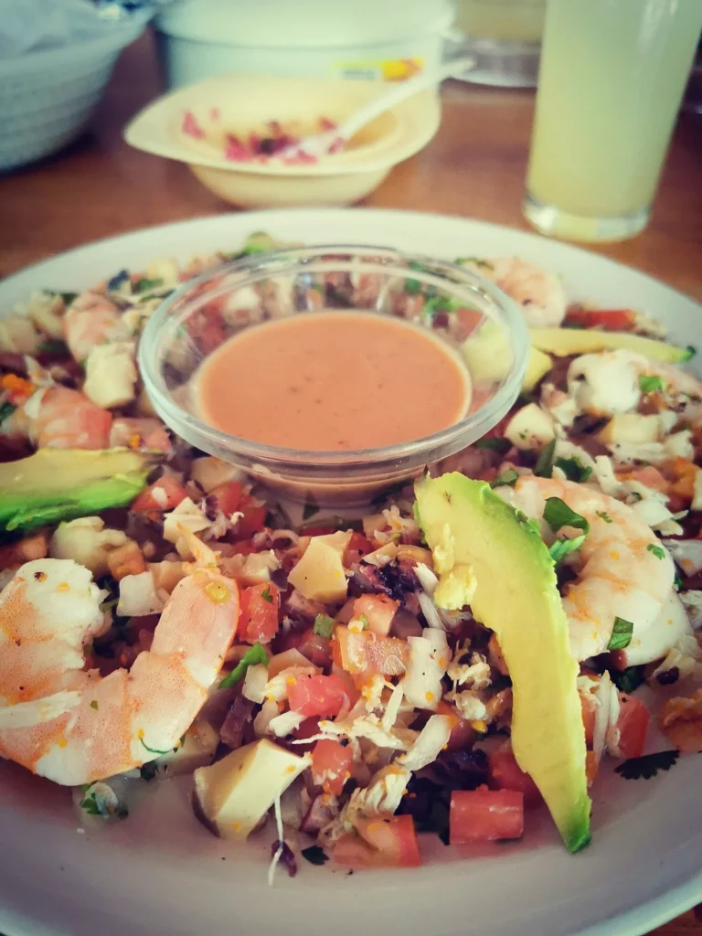 Delicious fish ceviche topped with creamy avocado slices and tangy lime dressing