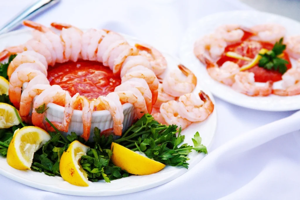 A close-up of a shrimp cocktail spoon filled with the zesty tomato-based sauce and succulent shrimp