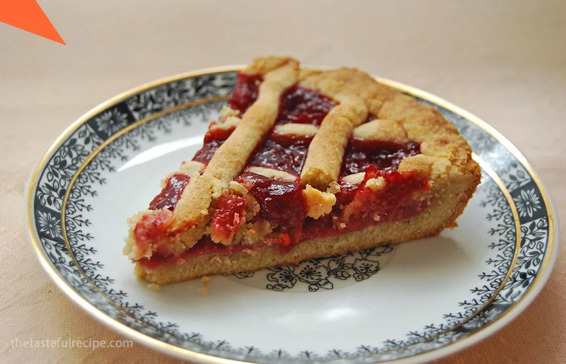 A slice of Crostata served with a dollop of whipped cream on top