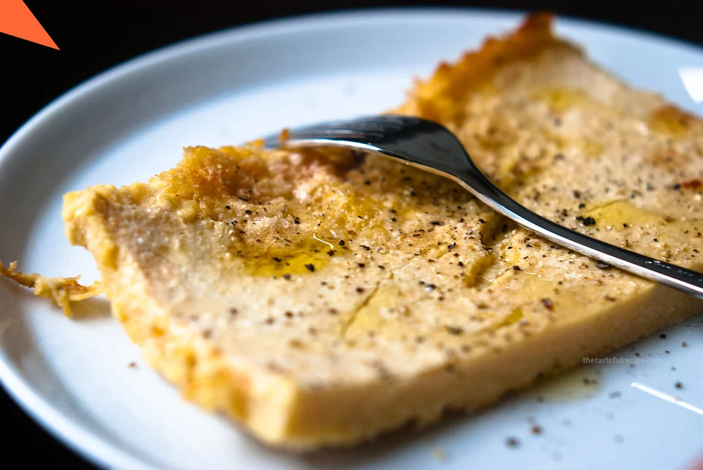 liced Farinata garnished with fresh rosemary and black pepper, ready to be served