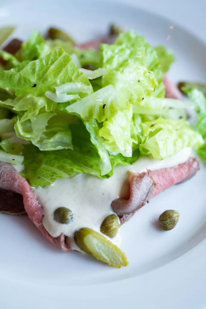 vitello tonnato served with sauce and lettuce