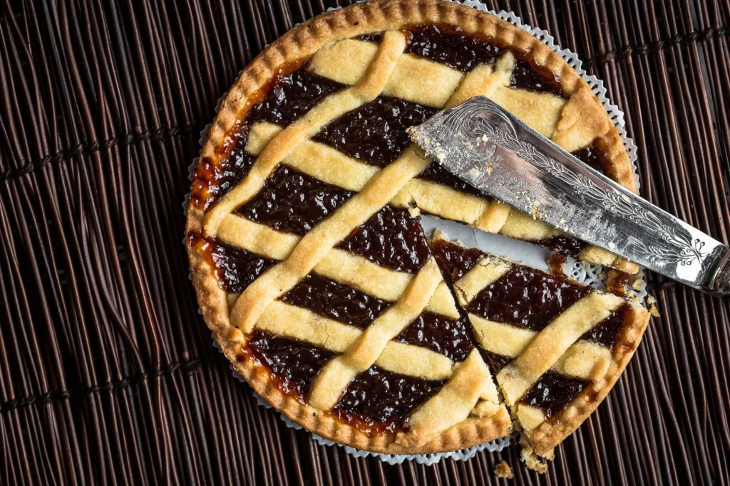 A slice of Crostata showing the flaky crust and the delicious fruit filling inside