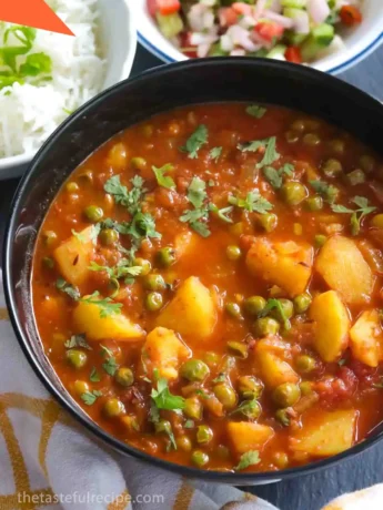 Sprinkling chopped coriander leaves over the cooked Aloo Matar