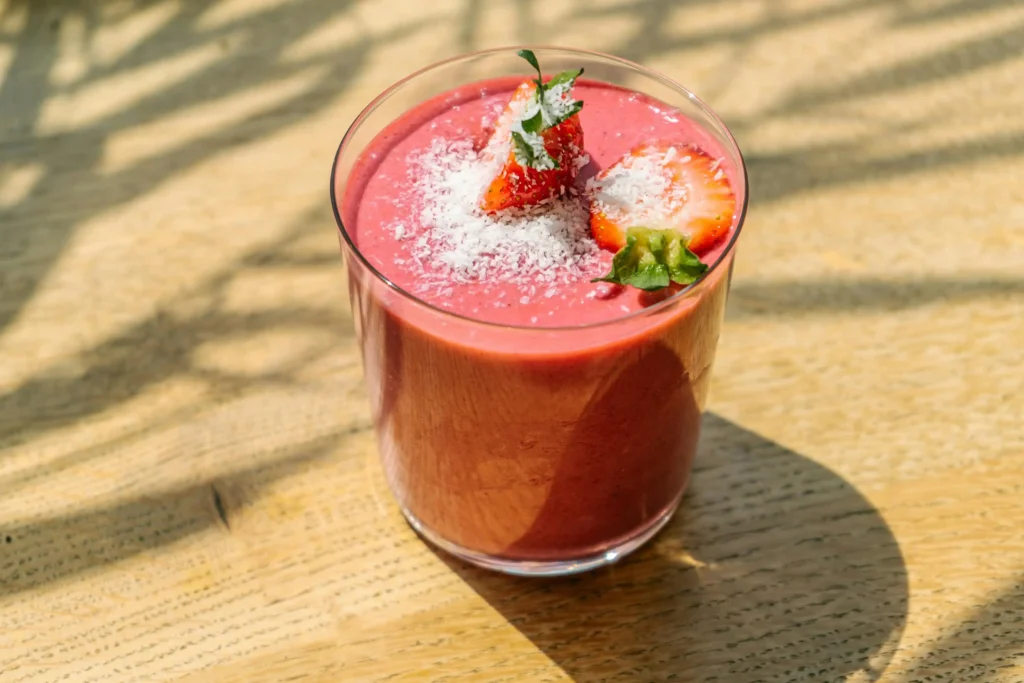 Clear Strawberry Milkshake With Red Liquid on Brown Wooden Table