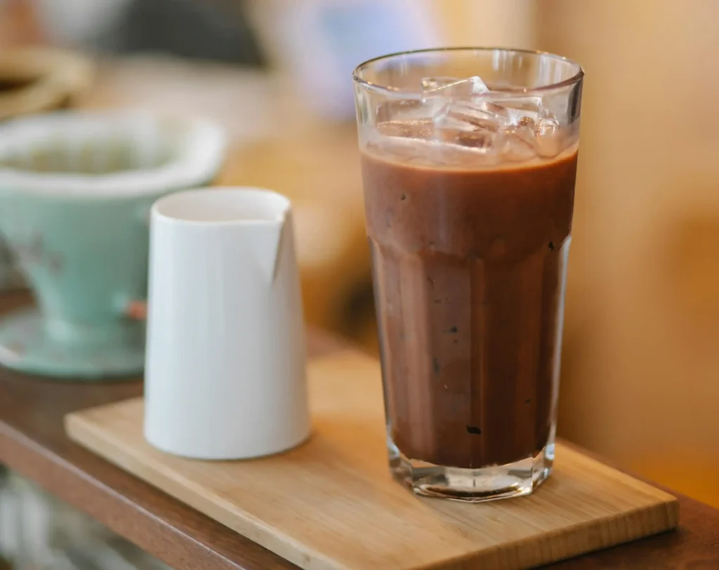 Delicious Cold Brew Coffee on wooden board with milk jigger