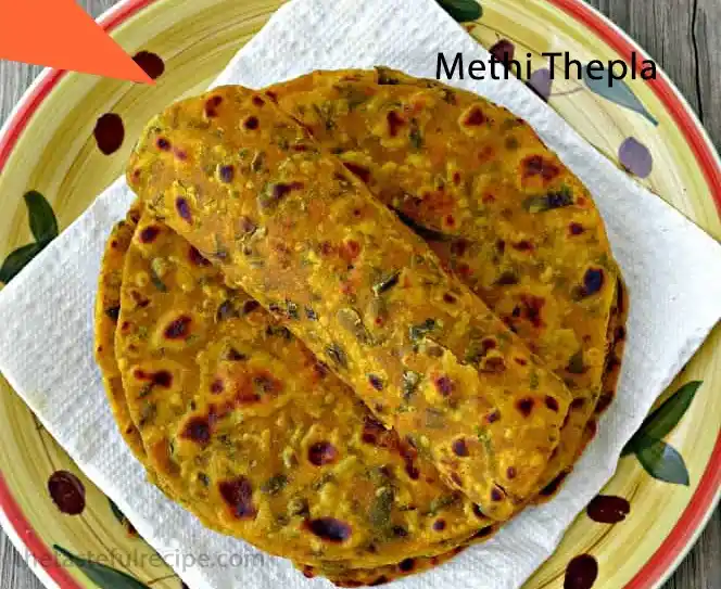 Multiple Methi Theplas cooking on a large tawa, ready to be served