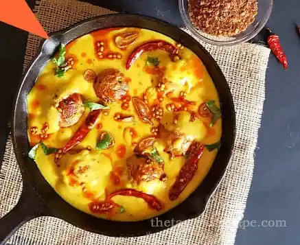 Pakoras being added to the Kadhi gravy in a pan