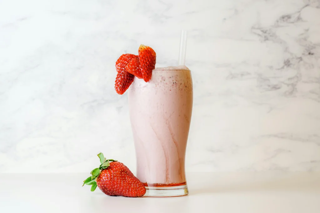 Delicious homemade Strawberry Milkshake topped with whipped cream and fresh strawberries