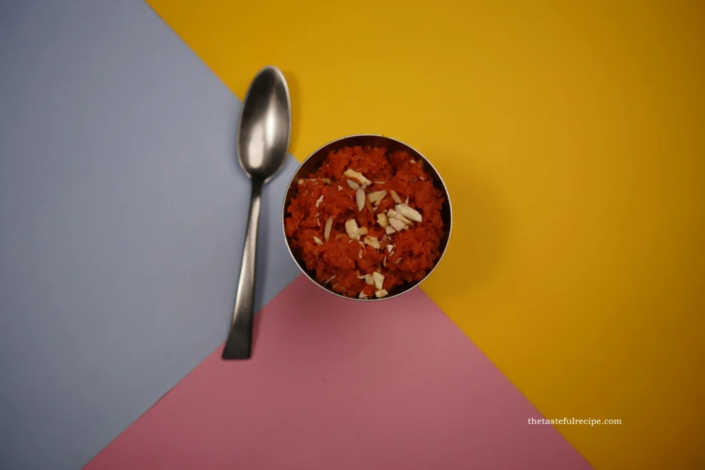 Gajar Halwa being spooned into individual serving bowls, garnished with nuts