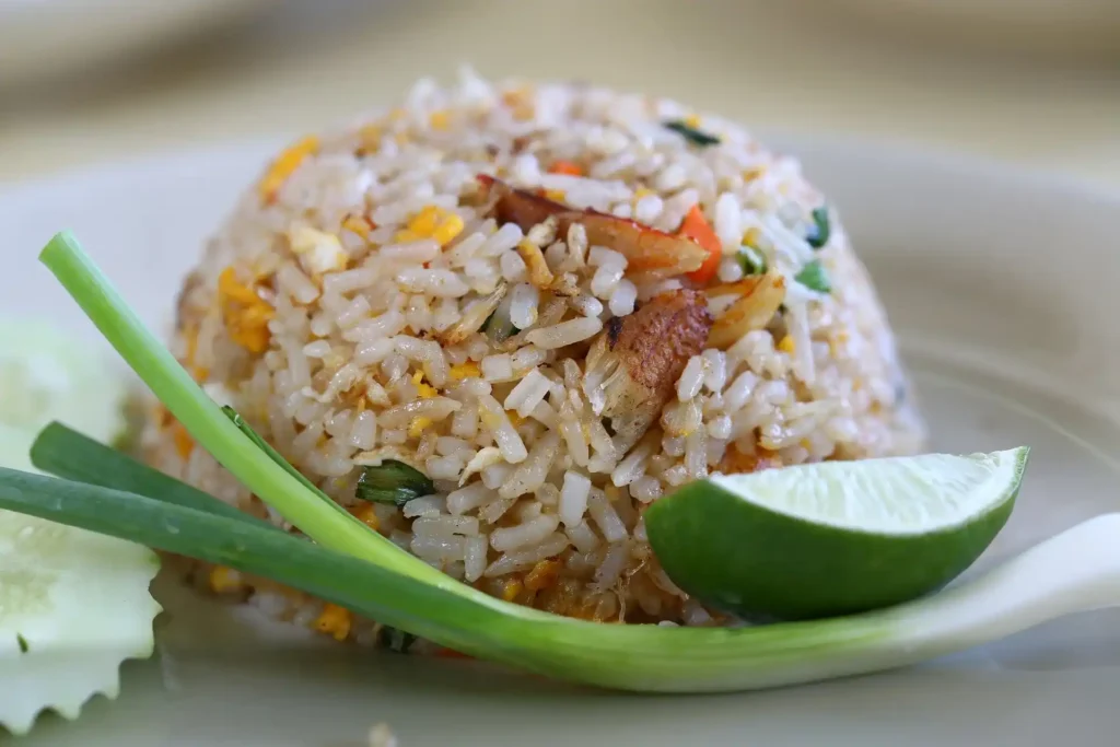 A beautifully plated dish of Shrimp Fried Rice, ready to eat, with a side of soy sauce.