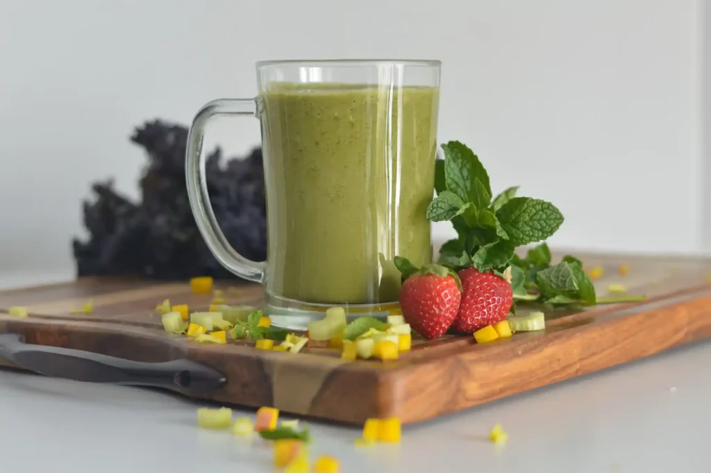 Child enjoying a green smoothie from a colorful cup