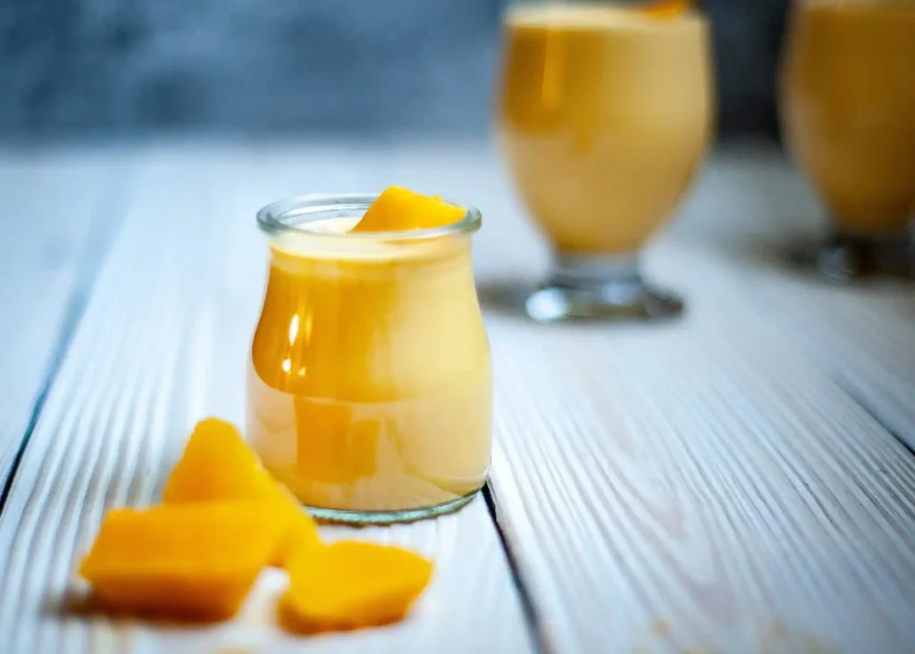 A nutritious Mango Smoothie served alongside a plate of breakfast toast and a cup of coffee