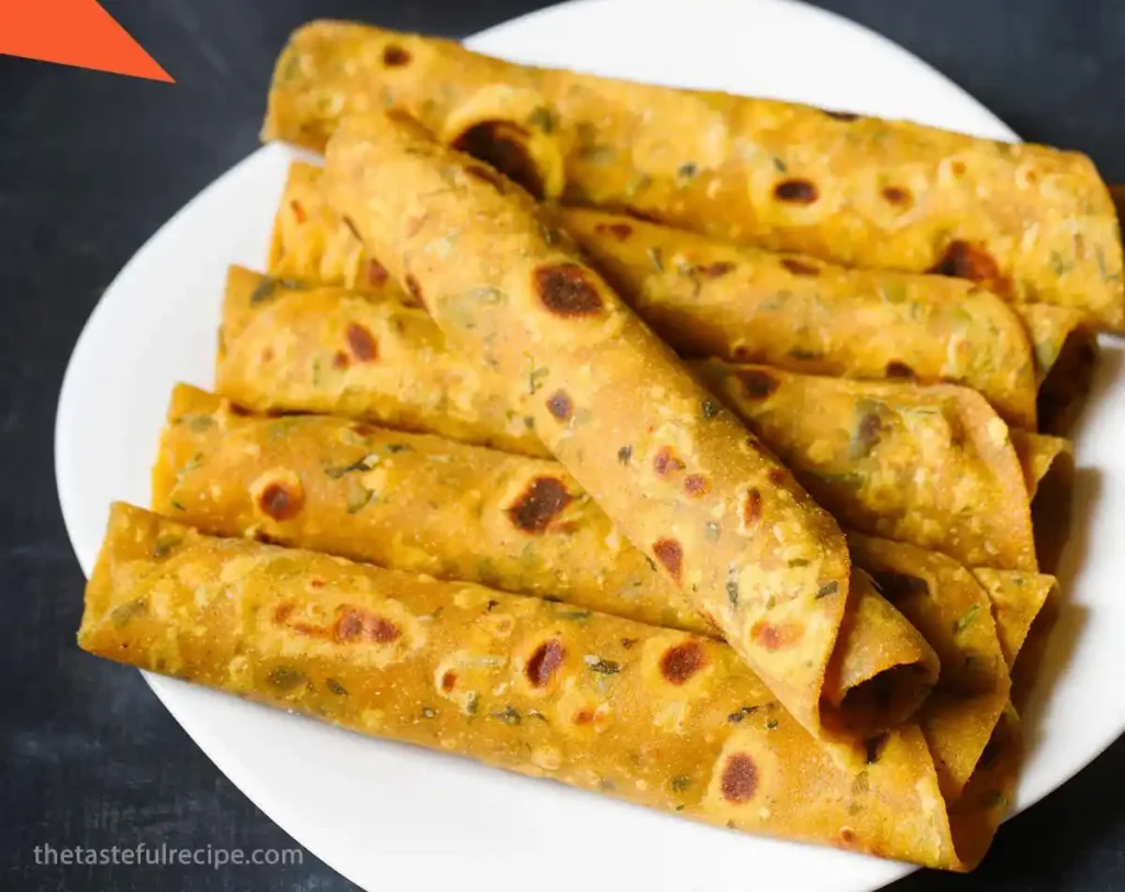 Rolling out the Methi Thepla dough into thin flatbreads on a floured surface