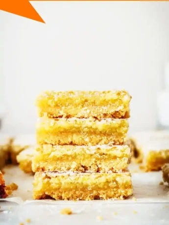 Close-up of a tangy lemon bar showing the smooth lemon filling and buttery shortbread crust