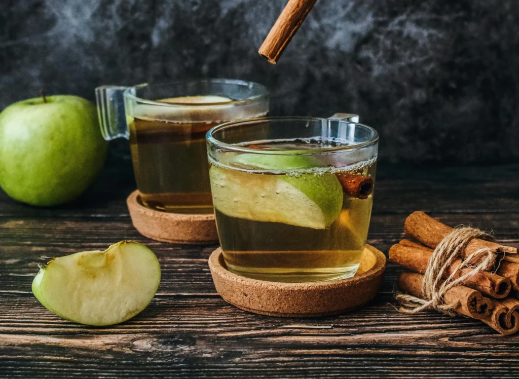 Pouring organic apple juice into a clean container for homemade apple cider vinegar