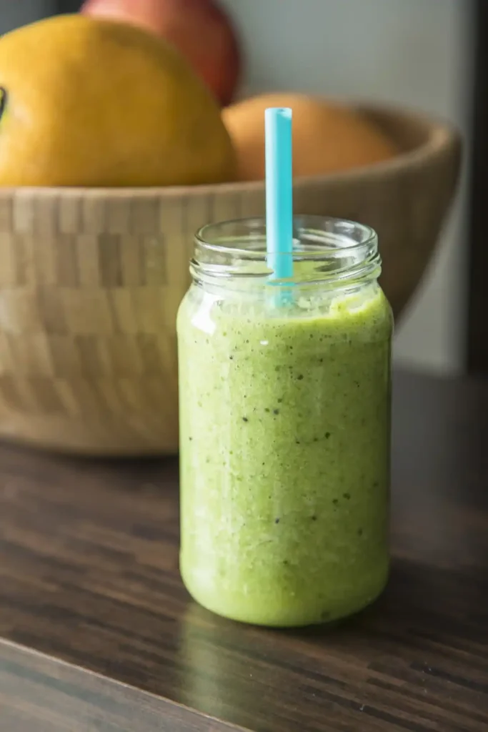 Pouring freshly blended Kiwi Smoothie into a clear glass