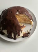 omemade Boston Cream Pie sliced and ready to serve on a white plate