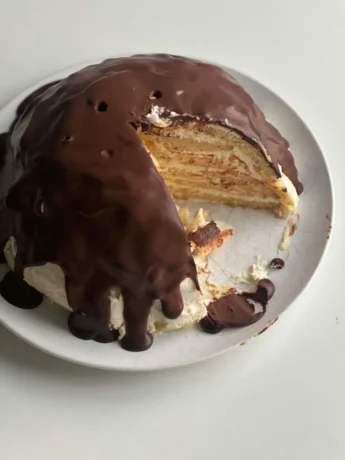 omemade Boston Cream Pie sliced and ready to serve on a white plate