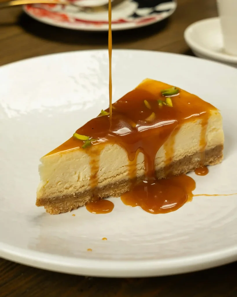 A slice of pumpkin cheesecake recipe with caramel sauce drizzled on top