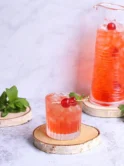 Close-up of cherry limeade with ice cubes and garnished with maraschino cherries and lime slices