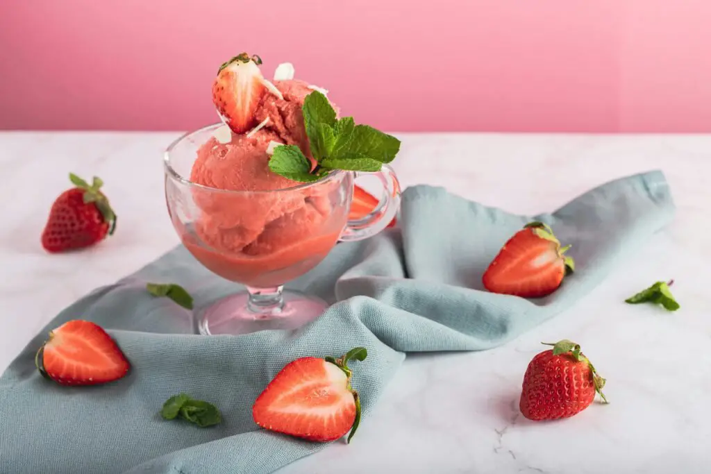 Raspberry Sorbet displayed next to fresh raspberries and lemons