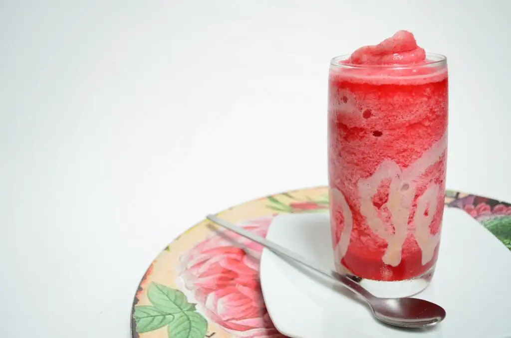 Refreshing Raspberry Sorbet scooped into cones on a wooden table