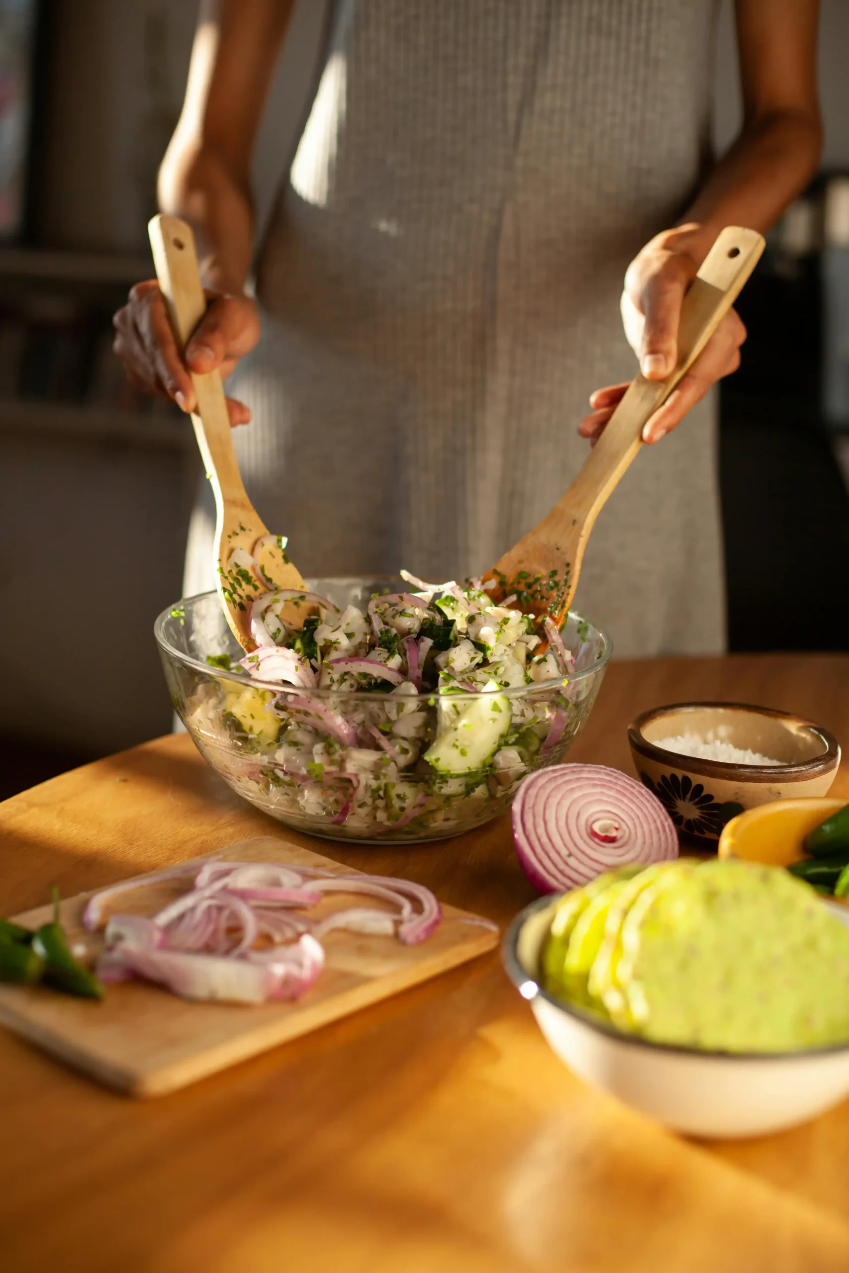 A Person Using Wooden Spoon in Mixing a Zucchini Salad