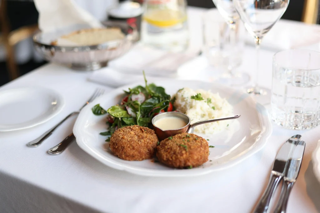 Crab cakes on a serving platter with a variety of dipping sauces