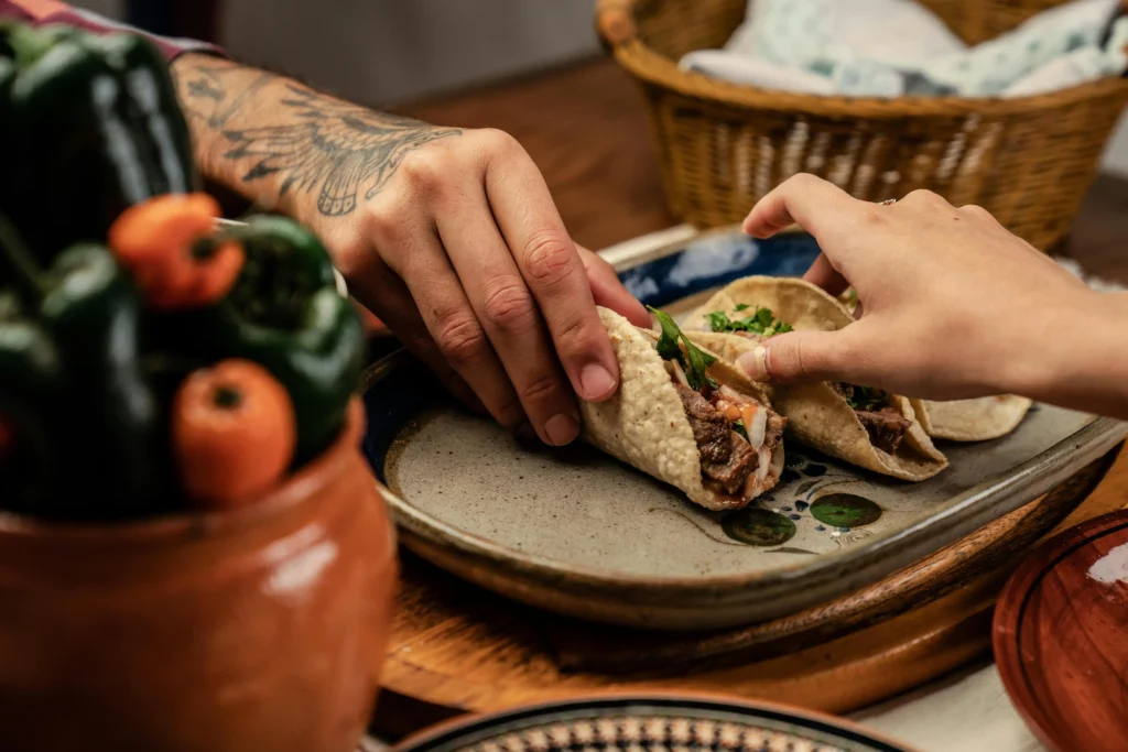 People Holding Tortilla with Carne Asada Tacos