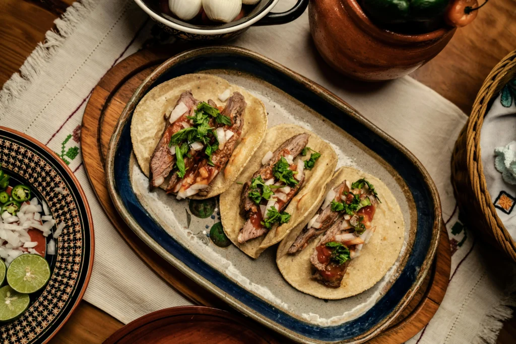 Sliced Beef Steak and Green Vegetable on top of Carne Asada Tacos