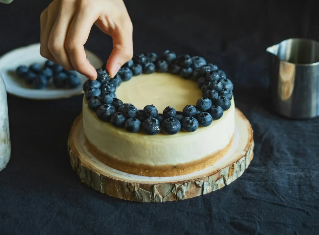 Woman Hand Putting Blueberries on Torta della Nonna