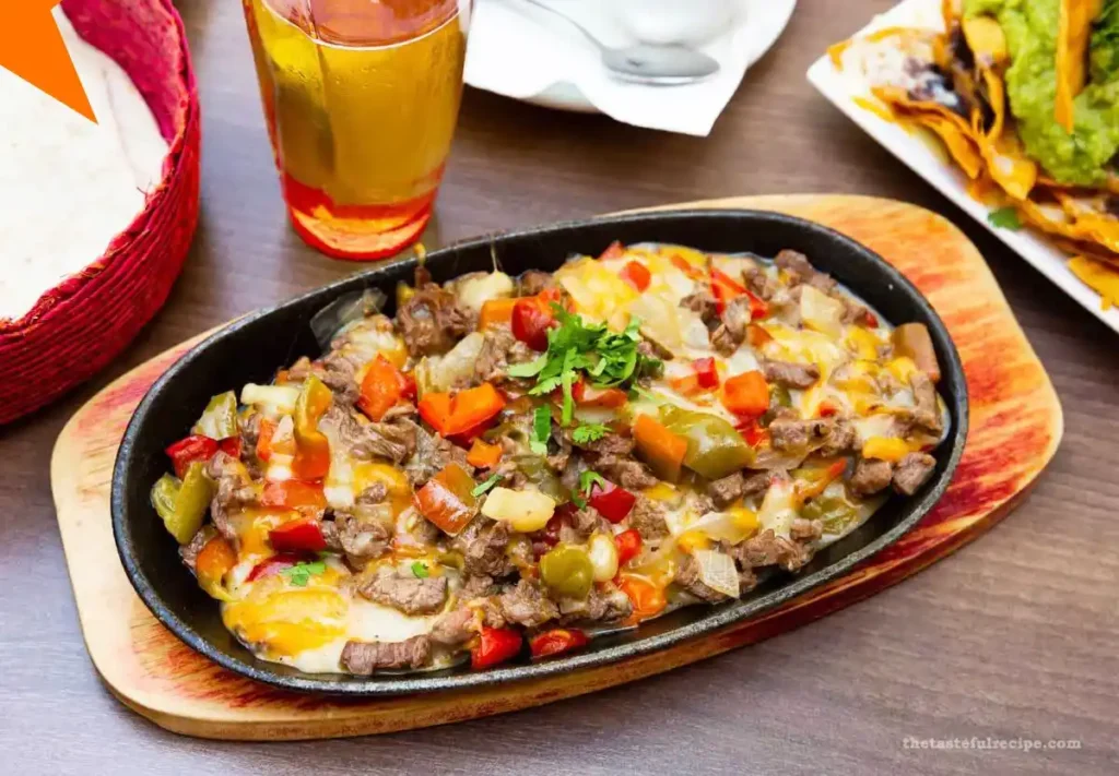 Alambre skillet topped with melted cheese and ready to be served with tortillas