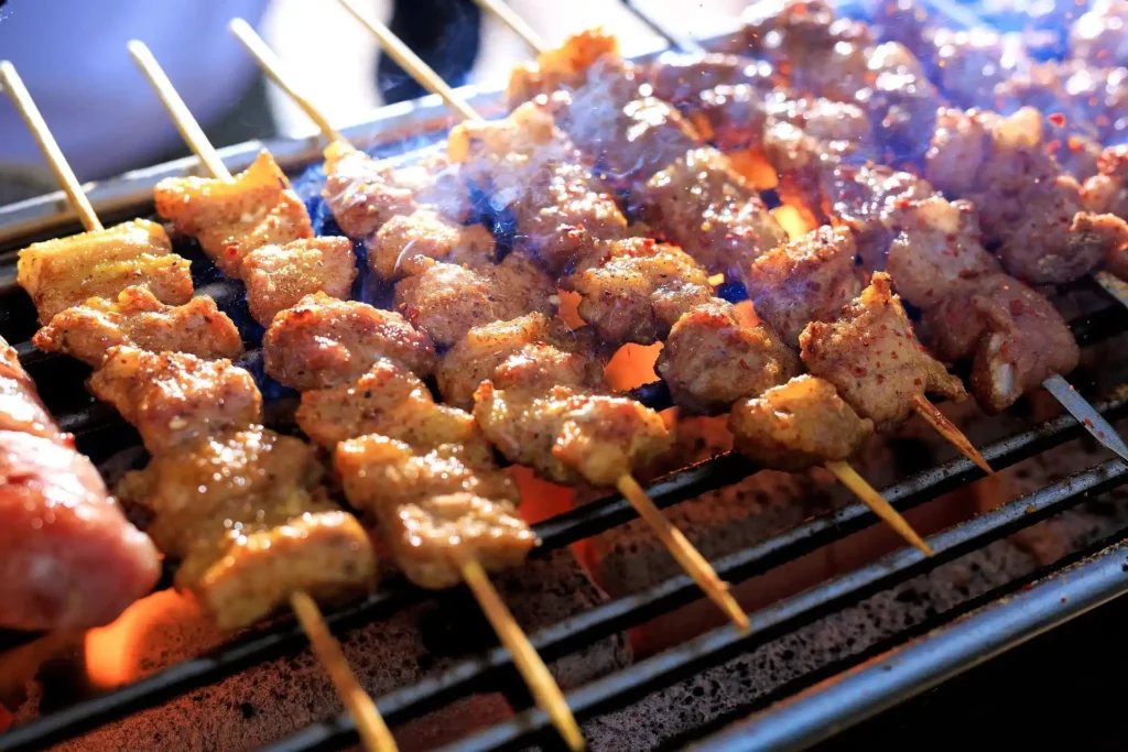 Chicken and vegetable Spiedini skewers on a BBQ grill with flames